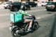 Kurier liefert Essen auf einem Roller.