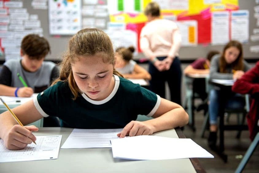 Schüler, die Prüfungen in einem Klassenzimmer ablegen.