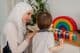 Ein muslimischer Lehrer und ein Vorschulkind spielen mit bunten Spielsachen