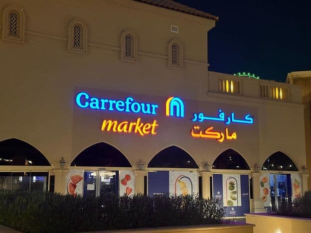 Beleuchtetes Logo von Carrefour-Markt mit arabischem Markennamen