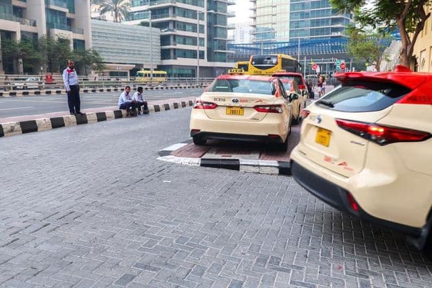 Eine Gruppe von Taxifahrern wartet vor einem Hotel in Dubai auf Fahrgäste.