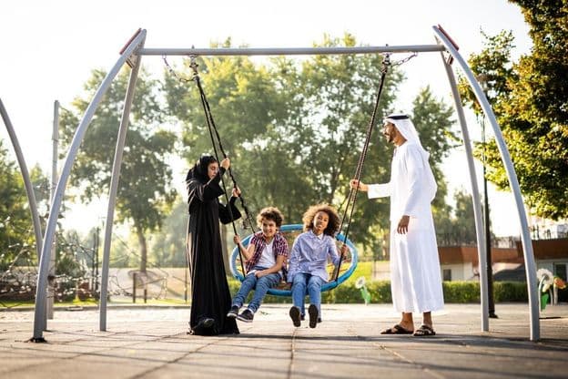 eine Familie spielt auf dem Spielplatz in Dubai
