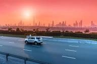 Autobahn und Stadtbild von Dubai bei Sonnenuntergang.