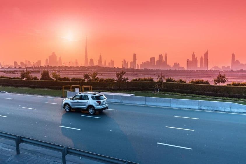 Autobahn und Stadtbild von Dubai bei Sonnenuntergang.