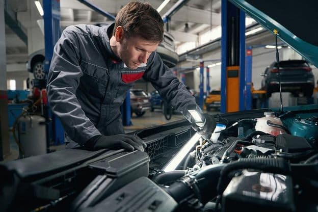 Der Arbeiter führt eine umfassende technische Inspektion des Autos durch
